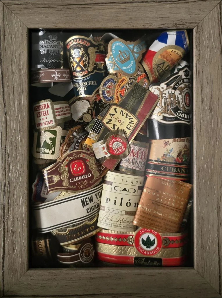 Tall shadow box of cigar bands arranged in a colorful mosaic
