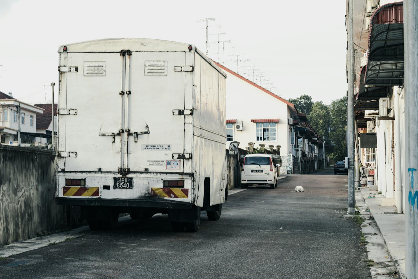 Box truck on commercial delivery route through residential service area — Dumpster Breath route distribution